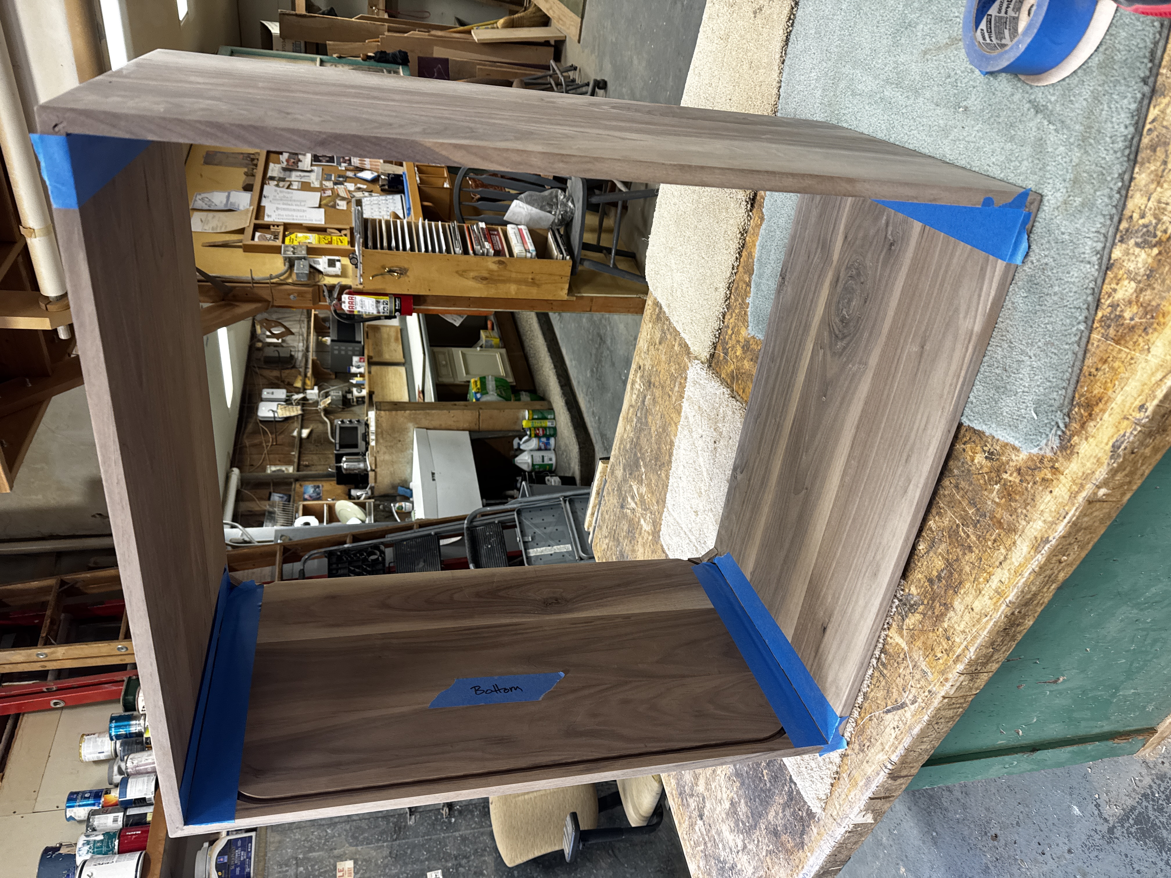Sanding the glued body of the record cabinet.